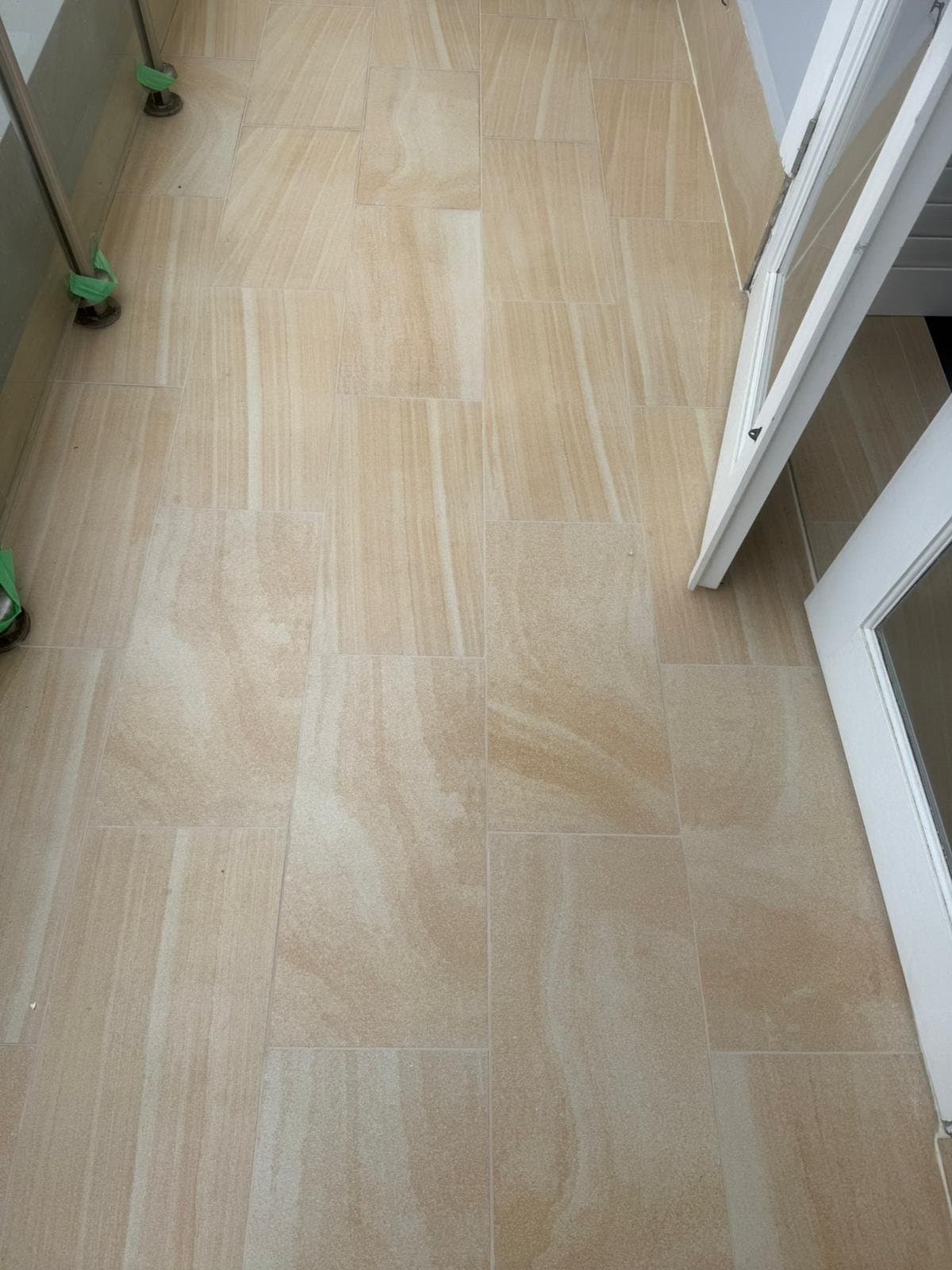 The same balcony tiles clean and evenly coloured, grout lines restored