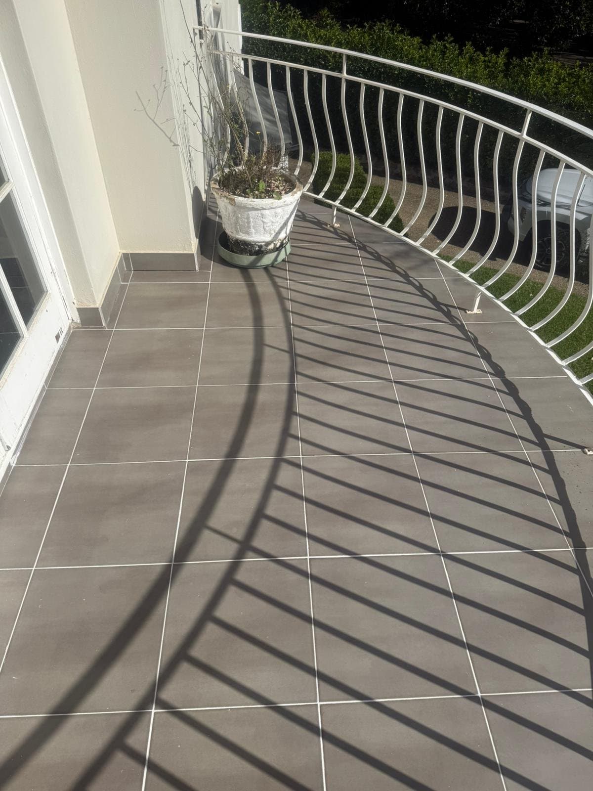The same curved terrace with the tiles and grout cleaned up