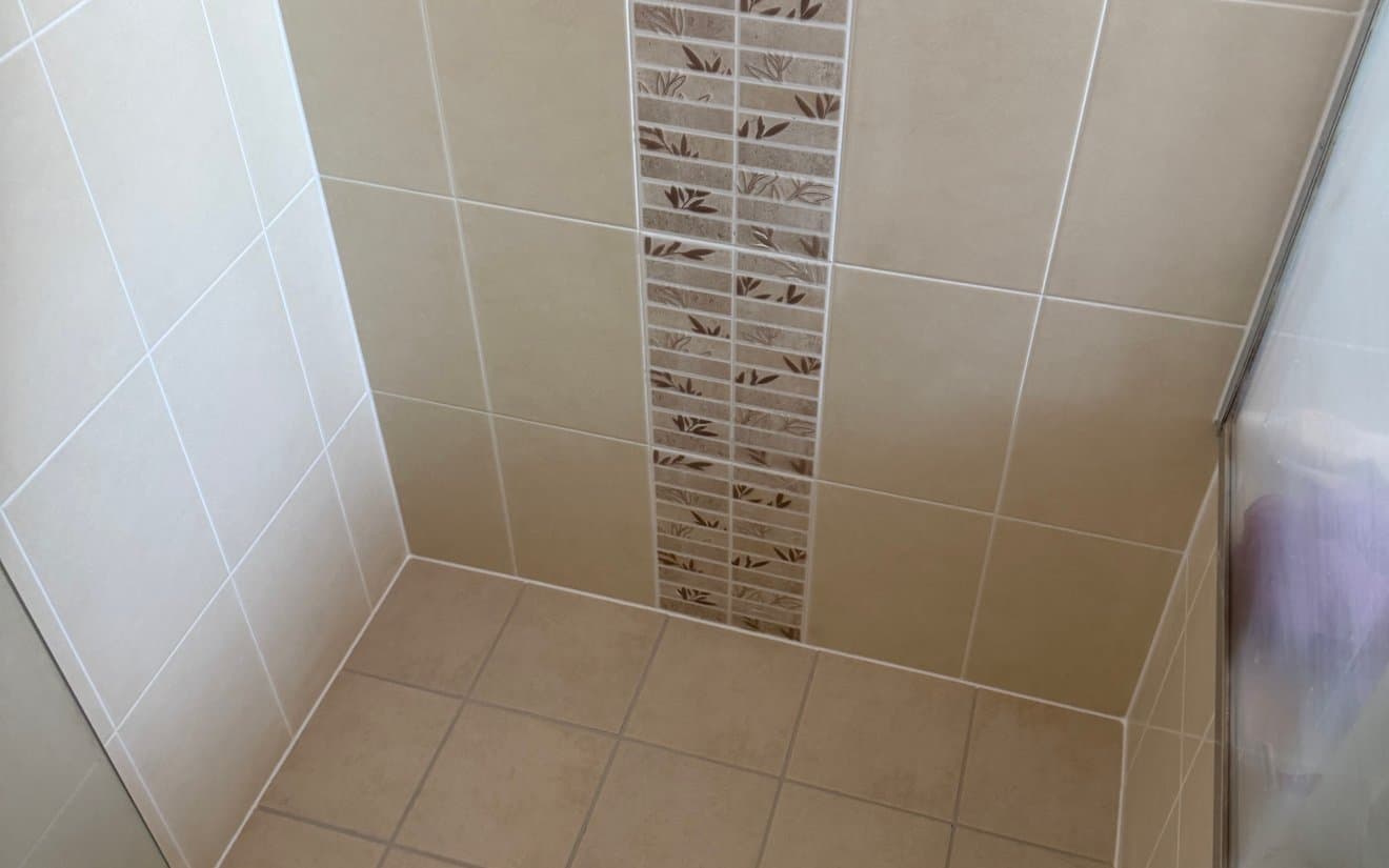 A tiled shower repaired by Seal Masters, with clean grout and a sealed floor